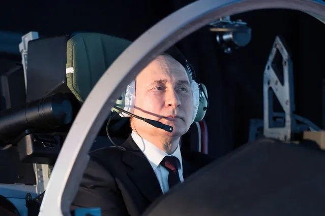 In this pool photograph distributed by the Russian state owned agency, Russian President Vladimir Putin operates a simulator during a visit at the Krasnodar Higher Military Aviation School of Pilots in Krasnodar on March 7, 2024. (Photo by Mikhail Metzel/Pool via AFP Photo)