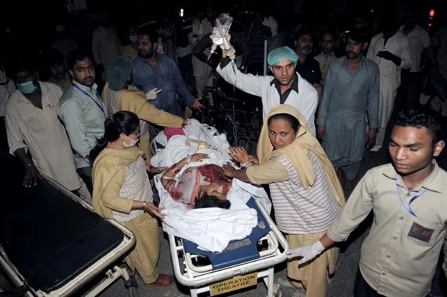 Pakistani relatives and emergency workers carry an injured woman to the hospital in Lahore on March 27, 2016, after at least 56 people were killed and more than 200 injured when an apparent suicide bomb ripped through the parking lot of a crowded park in the Pakistani city of Lahore where Christians were celebrating Easter. (Photo by Arif Ali/AFP Photo)