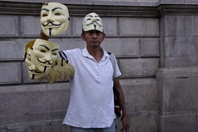 A vendor sells Guy Fawkes masks during a demonstration to celebrate the resignation of Guatemalan Vice President Roxana Baldetti, and to demand the resignation of President Otto Perez Molina, outside Congress in Guatemala City, May 9, 2015. Baldetti resigned on May 8 to face an investigation over her alleged involvement in a customs corruption racket, amid a scandal that has hurt the ruling party ahead of elections. (Photo by Jorge Dan Lopez/Reuters)