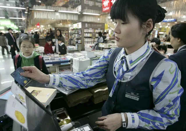A cashier uses a customer's credit card to pay for a purchase at a Kyobo bookstore in Seoul in this February 5, 2009 file photo. (Photo by Jo Yong-Hak/Reuters)