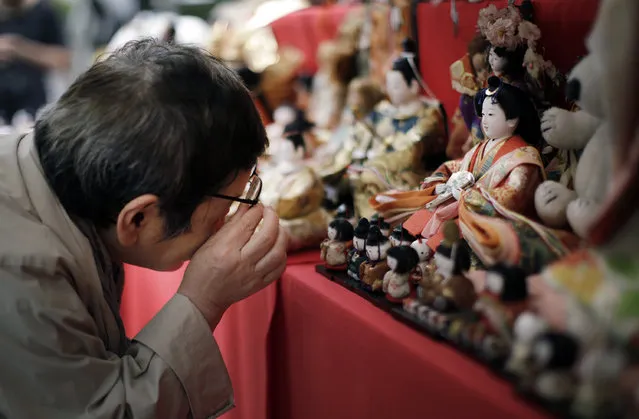 A visitor looks at sacrificed dolls during the Festival of Repayment of Kindness at Dairoku-tensakaki Shrine in Tokyo, Saturday, May 16, 2015. Traditionally, it is believed that the dolls can give good health and happiness to children by absorbing sickness and ill fate. The dolls are then sacrificed during the festival after they have protected their young owners. (Photo by Eugene Hoshiko/AP Photo)