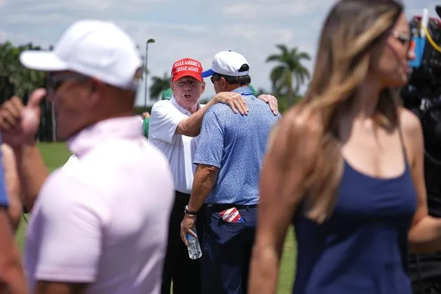 Republican presidential candidate former President Donald Trump, center left, greets people as he visits the driving range ahead of the final round of LIV Golf Miami, at Trump National Doral Golf Club, Sunday, April 7, 2024, in Doral, Fla. (Photo by Rebecca Blackwell/AP Photo)