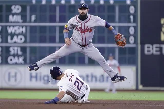 Atlanta Braves second baseman Luis Guillorme, top, jumps over Houston Astros designated hitter Yainer Diaz (21) after throwing to first base as Diaz slides into second base on Guillorme's attempted double play during the fourth inning of a baseball game Wednesday, April 17, 2024, in Houston. Jeremy Pena was safe at first. (Photo by Michael Wyke/AP Photo)