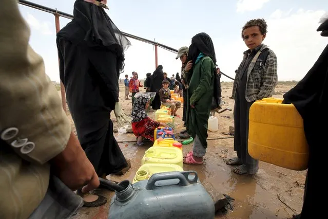 People fill jerrycans with water from a public tap amidst an acute water shortage in Sanaa May 13, 2015. (Photo by Mohamed al-Sayaghi/Reuters)