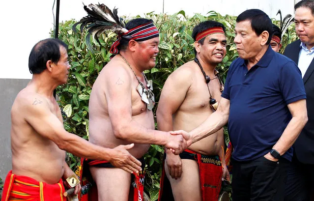 Philippine President Rodrigo Duterte greets Igorot dance performers in native costumes during a visit in Baguio city, Philippines March 11, 2017. (Photo by Harley Palangchao/Reuters)