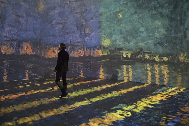 A man walks in front of a video projection in the exhibition “Monet 2 Klimt” in Dresden, Germany, 14 March 2017. The exhibition which is scheduled to run from 17 March to 15 June 2017 features paintings by artists Claude Monet, Vincent van Gogh and Gustav Klimt that are being projected onto screens as part of a multimedia show. (Photo by: Sebastian Kahnert/picture-alliance/DPA/AP Images)