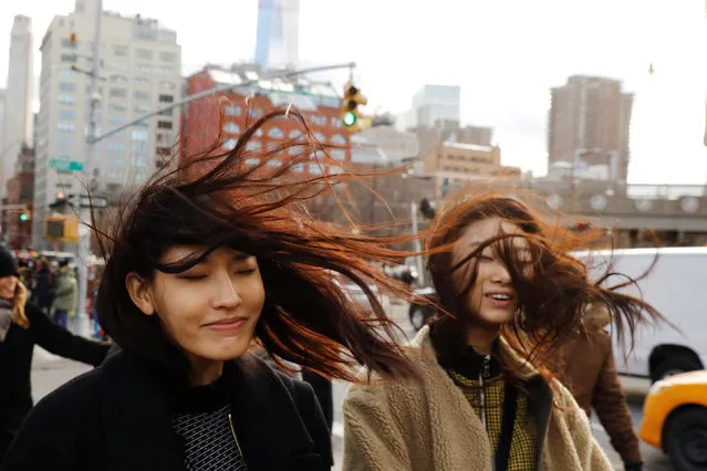 Two women react as the wind blows their hair around while walking on the street in the Manhattan borough of New York, U.S., February 13, 2017. (Photo by Lucas Jackson/Reuters)