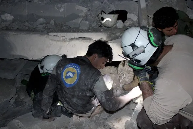 Civil defense team members and people try to rescue people who were trapped under the debris of a Mosque after an aerial attack on a mosque during prayer in the Cina village of Etarib district of Aleppo, Syria on March 16, 2017. 58 civilians killed in the attack. (Photo by Ibrahim Ebu Leys/Anadolu Agency/Getty Images)