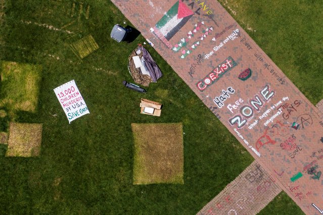 A drone view shows marks left by tents next to signs as people pack up to leave a protest encampment, organized in support of Palestinians in Gaza, during the ongoing conflict between Israel and the Palestinian Islamist group Hamas, after protesters agreed to voluntarily end the camp by Monday afternoon at the University of Washington in Seattle, Washington on May 20, 2024. (Photo by David Ryder/Reuters)