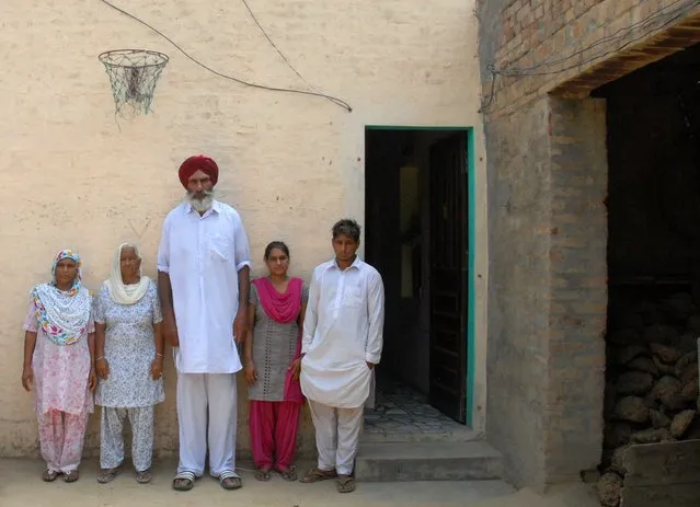 The family of newly drafted Indian NBA basketball player Satnam Singh (L/R): mother Sukhwinder Kaur, neighbour Kartar Kaur, father Balbir Singh Bhamara, sister Sarabjot Kaur and brother Beant Singh pose under a basketball hoop at his family home in the village of Ballo Ke, some 50kms south of Jalandhar on June 29, 2015. (Photo by Shammi Mehra/AFP Photo)