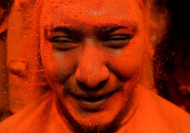 A devotee smiles while being smeared with vermilion powder as he celebrates the “Sindoor Jatra” vermillion powder festival to welcome the arrival of spring and Nepali New Year at Thimi in Bhaktapur, Nepal on April 14, 2024. (Photo by Navesh Chitrakar/Reuters)