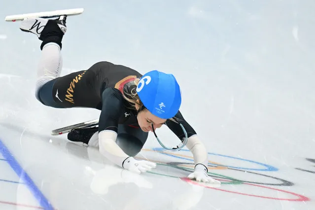 Germany's Michelle Uhrig falls down as she competes in the women's speed skating mass start semifinal during the Beijing 2022 Winter Olympic Games at the National Speed Skating Oval in Beijing on February 19, 2022. (Photo by Sebastien Bozon/AFP Photo)