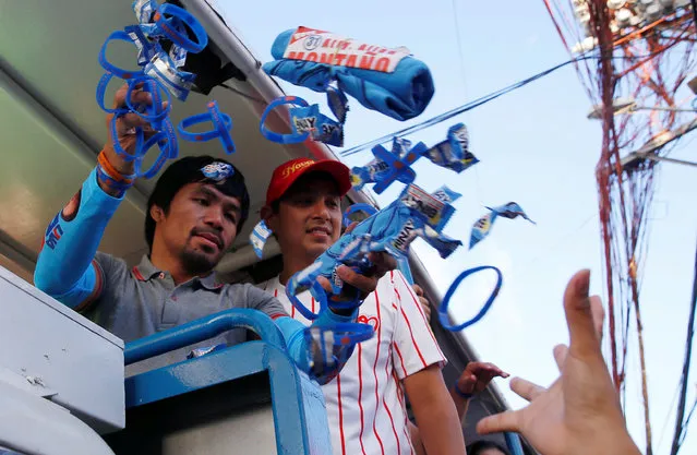 Filipino boxer and Senatorial candidate Manny Pacquiao throws election souvenir wrist bands and shirts to supporters during election campaigning in Malabon Metro Manila in the Philippines May 6, 2016. (Photo by Erik De Castro/Reuters)