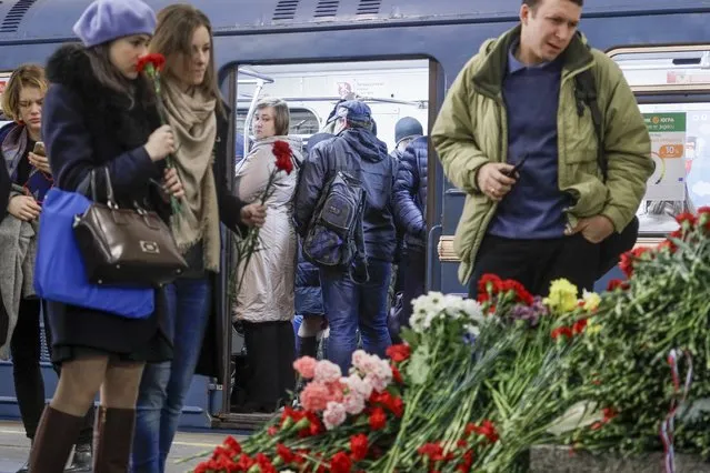 People lay flowers at a symbolic memorial at Technologicheskiy Institute subway station in St. Petersburg, Russia, Wednesday, April 5, 2017. (Photo by Dmitri Lovetsky/AP Photo)