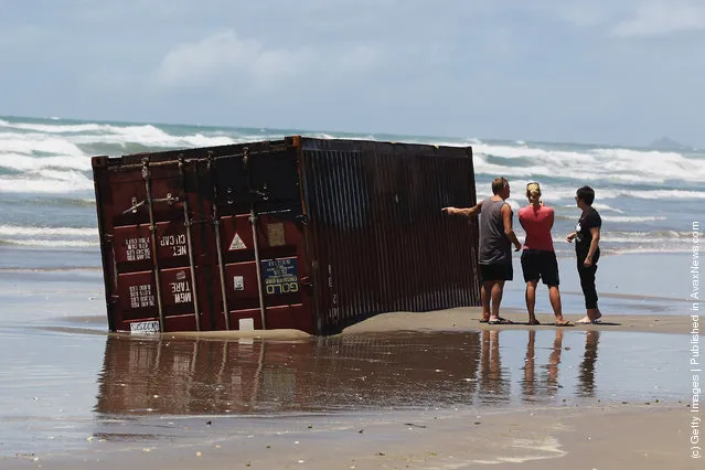 Residents check washed up containers at Waihi Beach in Tauranga, New Zealand