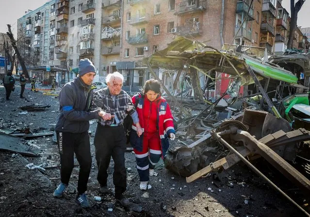 People and medics help a wounded resident of a house destroyed by shelling as Russia's attack on Ukraine continues, in Kyiv, Ukraine on March 14, 2022. (Photo by Gleb Garanich/Reuters)