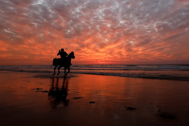 A Palestinian man rides a horse on a beach, in Gaza City on January 21, 2022. (Photo by Mohammed Salem/Reuters)