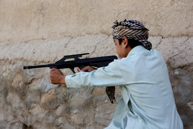 In this Saturday, July 25, 2015 photo, an Afghan boy plays with his friends using a toy gun, in Kabul, Afghanistan. At least 184 people, nearly all children, suffered eye injuries over the recent Eid al-Fitr holiday from toy weapons that fire BB pellets and rubber shot, health officials said. In response, authorities have called on police to destroy all the toy guns officers comes across. (Photo by Rahmat Gul/AP Photo)