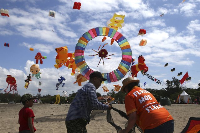 Participants prepare a kite during Denpasar international kite festival in Sanur, Bali, Indonesia Friday, August 16, 2024. (Photo by Firdia Lisnawati/AP Photo)