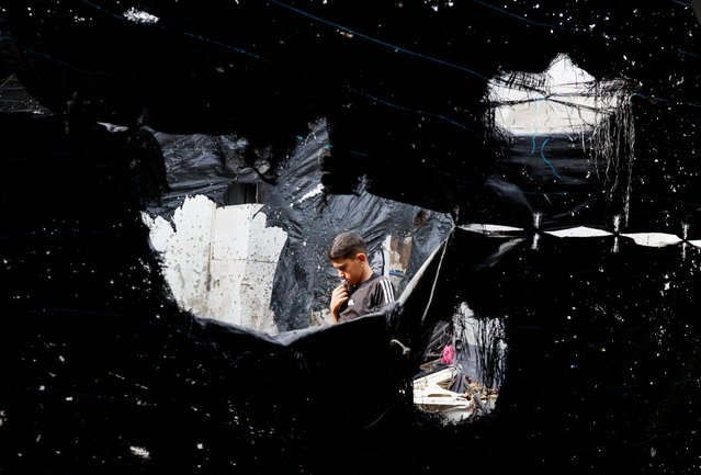 A Palestinian boy walks at the site of an Israeli drone strike in Nur Shams refugee camp in Tulkarm in the Israeli-occupied West Bank on August 27, 2024. (Photo by Mohammed Torokman/Reuters)