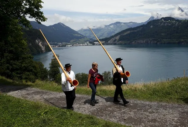 Spectators and alphorn blowers arrive for the Swiss national holiday celebrations on the Ruetli meadows in central Switzerland August 1, 2015. (Photo by Arnd Wiegmann/Reuters)