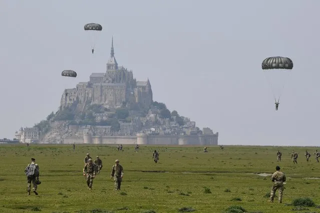 US paratroopers walk back after jumping over Le Mont-Saint-Michel, north-western France on May 18, 2019, less than three weeks before the 75th anniversary of the D-Day landings. In what remains the biggest amphibious assault in history, some 156,000 Allied personnel landed in France on June 6, 1944. An estimated 10,000 Allied troops were left dead, wounded or missing, while Nazi Germany lost between 4,000 and 9,000 troops, and thousands of French civilians were killed. The 75th anniversary of the D-Day landings will fall on June 6, 2019. (Photo by Damien Meyer/AFP Photo)