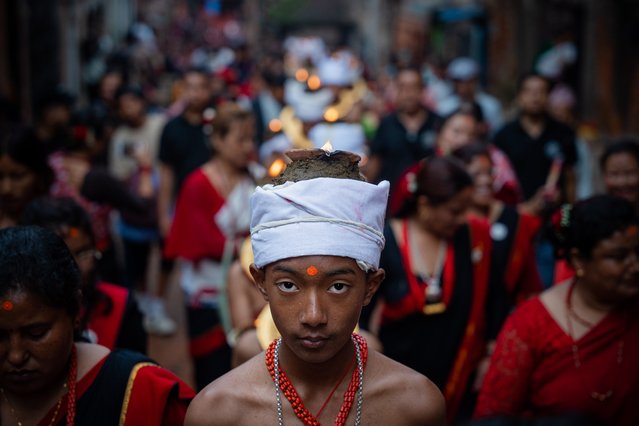 Devotees with lit oil lamps perform religious rituals while offering prayer to God Narayan during Krishna Janmashtami, or the birth anniversary of Lord Krishna, in Bhaktapur, Nepal on August 26, 2024. (Photo by Amit Machamasi/ZUMA Press Wire/Rex Features/Shutterstock)