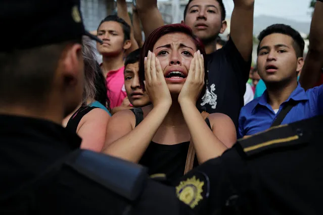 The relative of a juvenile offender reacts as policemen blocks a road during a riot at Las Gaviotas juvenile detention center in Guatemala City, Guatemala, July 3, 2017. (Photo by Luis Echeverria/Reuters)