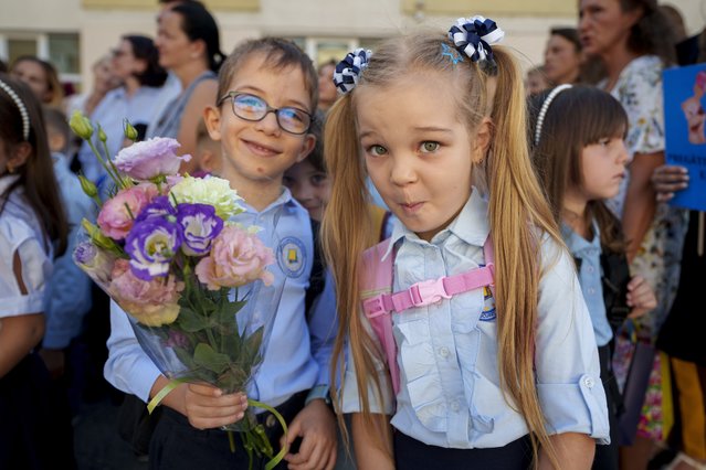 Astryd and Adam, 6 and a half years-old, strike a pose during a ceremony marking the beginning of the school year at the Orizont Elementary School in Bucharest, Romania, Monday, September 9, 2024. (Photo by Vadim Ghirda/AP Photo)