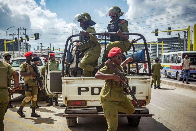 Tanzanian police officers get out of a police vehicle while patrolling the streets ahead of a demonstration over the alleged kidnapping and killing of opposition members in Dar es Salaam on September 23, 2024. Police arrested Tanzania's top opposition figures on September 23, 2024, their party and police said, as the authorities moved to block a mass protest in the commercial capital Dar es Salaam Despite an official ban, the opposition Chadema party had vowed to go ahead with the rally over the alleged kidnapping and killing of its members by security forces. (Photo by Alinanuswe Mwanguku/AFP Photo)