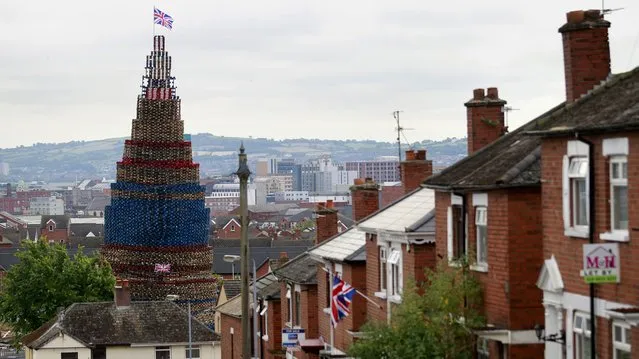 A massive loyalist bonfire dwarfs the houses near by in the Shankill area of West Belfast, Northern Ireland, Thursday, July 10, 2014. Thousands of bonfires have been built in Protestant areas across Northern Ireland that will be lit on the 11th Night referring to the night before the 12th of July, an annual Protestant commemoration of the 1690 Battle of the Boyne. (Photo by Peter Morrison/AP Photo)
