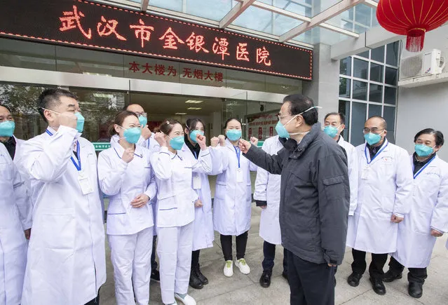 In this photo released by China's Xinhua News Agency, Chinese Premier Li Keqiang, center, speaks with medical workers at Wuhan Jinyintan Hospital in Wuhan in central China's Hubei province, Monday, January 27, 2020. China on Monday expanded its sweeping efforts to contain a deadly virus, extending the Lunar New Year holiday to keep the public at home and avoid spreading infection. (Photo by Li Tao/Xinhua via AP Photo)