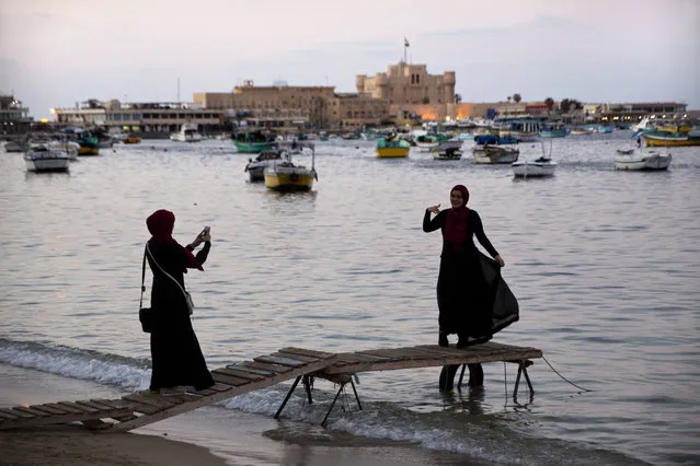 In this Sunday, March 26, 2017, a visitor poses for a picture on the Mediterranean Sea coast, in Alexandria, Egypt. (Photo by Amr Nabil/AP Photo)