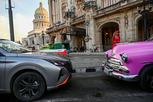 A new car is seen parked in front of an old American car near the Havana Capitol on September 5, 2024. Brand new Mercedes Benzes, pickup trucks, Wrangler Jeeps, and even some Teslas: in the midst of a severe economic crisis in Cuba, high-end cars have begun to steal the limelight from the American classics of the 1950s and the Soviet Lada and Moskvich compacts. (Photo by Yamil Lage/AFP Photo)