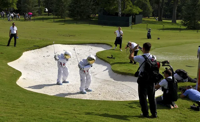 Sergio Garcia, center left, and Rory McIlroy, center right, become astronauts for an advertisement at Quail Hollow Club in Charlotte, N.C., Monday, August 7, 2017. (Photo by Jeff Siner/The Charlotte Observer via AP Photo)