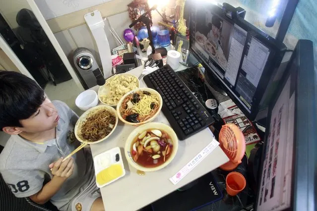 In this Monday, August 17, 2015 photo, Kim Sung-jin, 14, broadcasts himself eating delivery Chinese food in his room at home in Bucheon, south of Seoul, South Korea. (Photo by Julie Yoon/AP Photo)