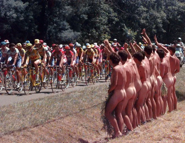A group of naked spectators wave at the pack during the 19th stage of the Tour de France cycling race between Hendaye and Bordeaux, southwestern France Friday July 19, 1996. The race ends Sunday in Paris. (Photo by Laurent Rebours/AP Photo)