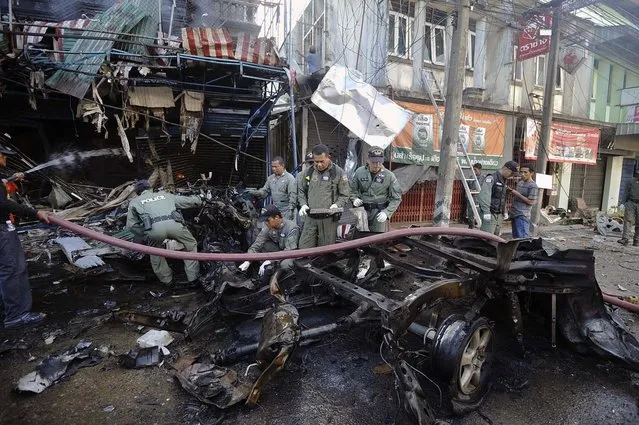 Members of a Thai bomb squad unit inspect the site of a car bomb attack in Thailand's restive southern Narathiwat province, on July 20, 2012. Two civilians were killed and four wounded in bomb and shooting attacks in southern Thailand, a military spokesman said, as the region marked the start of the Islamic holy month of Ramadan. (Photo by Madaree Tohlala/AFP Photo)