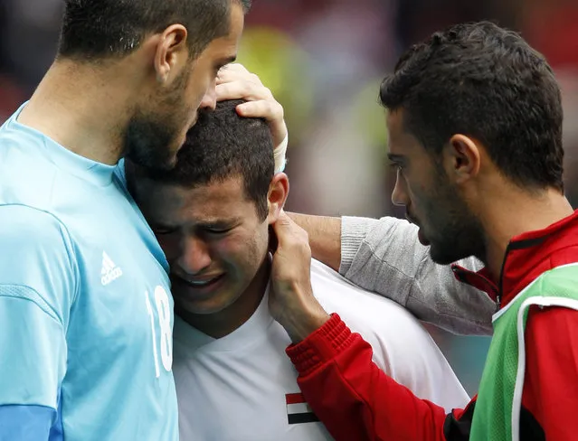 Goalkeeper Mohamed Bassam (L) of Egypt comforts team mate Eslam Ramadan (C) as he cries after their men's quarterfinal soccer match against Japan at the London 2012 Olympic Games at Old Trafford in Manchester, August 4, 2012. (Photo by Andrea Comas/Reuters)