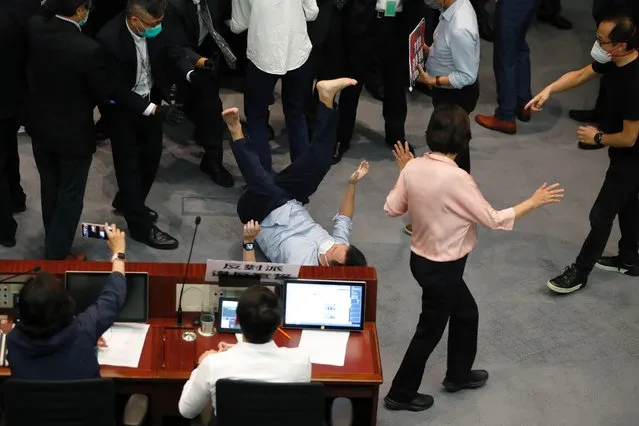 Pan-democratic legislator Raymond Chan Chi-chuen falls down as he scuffles with security and pro-China legislators during a Legislative Council's House Committee meeting, in Hong Kong, China May 8, 2020. Rival lawmakers scuffled in Hong Kong's legislature in a row over electing the chairman of a key committee, a fresh sign of rising political tension as the coronavirus pandemic tapers off in the Chinese-ruled city. (Photo by Tyrone Siu/Reuters)