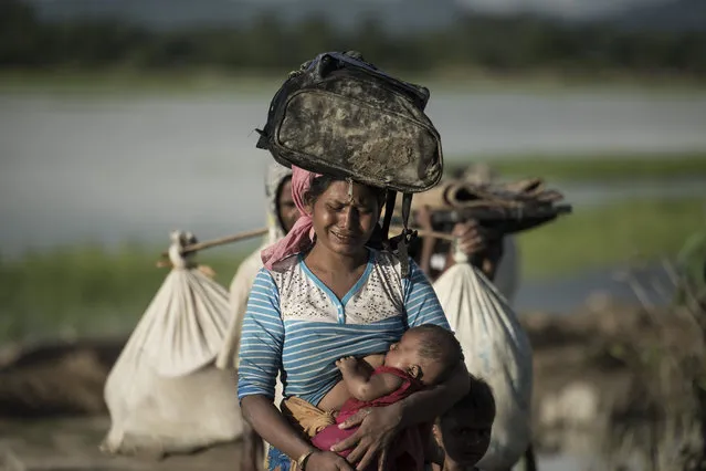 Rohingya refugee cries as she walks after crossing the Naf river from Myanmar into Bangladesh in Whaikhyang on October 9, 2017. A top UN official said on October 7 Bangladesh's plan to build the world's biggest refugee camp for 800,000-plus Rohingya Muslims was dangerous because overcrowding could heighten the risks of deadly diseases spreading quickly. The arrival of more than half a million Rohingya refugees who have fled an army crackdown in Myanmar's troubled Rakhine state since August 25 has put an immense strain on already packed camps in Bangladesh. (Photo by Fred Dufour/AFP Photo)