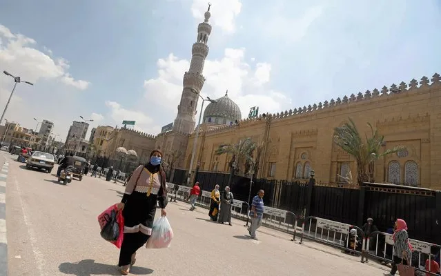 A woman wearing a face mask amid the coronavirus (COVID-19) walks in front of the closed Sayyida Zainab Mosque near markets that sell traditional lanterns in Cairo, Egypt, April 12, 2020. (Photo by Mohamed Abd El Ghany/Reuters)