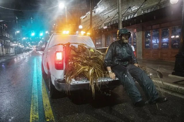 Lew Hendrix collects palm branches blown down by the outer bands of Hurricane Ian  in the Ybor City neighborhood of Tampa, FL, early Wednesday morning, September 28, 2022.  (Photo by Ted Richardson/The Washington Post)