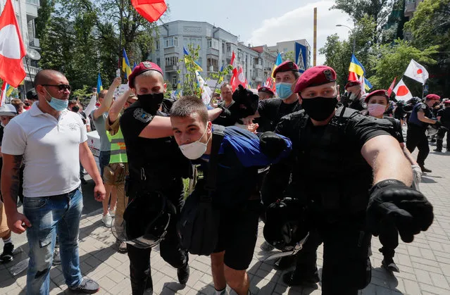 Ukrainian police officers detain a far-right militant who had previously allegedly attacked members and supporters of the Party of Shariy taking part in a protest rally in front of the Presidential Office in Kiev, Ukraine, 17 June 2020. (Photo by Sergey Dolzhenko/EPA/EFE)