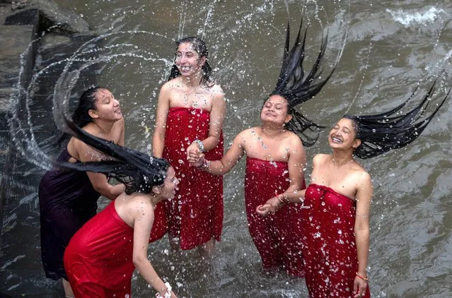 A group of women take a ritual holy bath to purify themselves to mark the Rishi Panchami festival, at Bagmati River in Kathmandu, Nepal, 01 September 2022. During Rishi Panchami, Nepalese women take a ritual bath in holy rivers and worship the ancient Sapta Rishi (seven saints), who devoted their life to the welfare of the society. However, some women practice this ancient ritual to ask for forgiveness for any errors committed during the end of their menstual cycle. In the Hindu religion, menstruation is viewed as a symbol of impurity and women are not supposed to take part in religious practices and sеxual activities during their periods. Thus, it is believed that Rishi Panchami is the occasion to wash off one's impurity for the whole year. (Photo by Narendra Shrestha/EPA/EFE/Rex Features/Shutterstock)