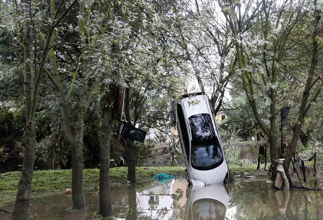 A destroyed car at a tree after heavy floods in Grabels, near Montpellier, Southern France, October 7, 2014. Parts of Montpellier lay under water after the Lez river, which flows through the city, burst its banks. Hundreds of people spent the night in the local train station. The floods are the second in the region this month. No fatalities were reported. (Photo by Guillaume Horcajuelo/EPA)