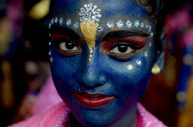 An Indian participant dressed as the Hindu god Lord Krishna looks on during a cultural event in the run up to the dahi handi (curd pot) celebrations of “Janmashtami”, which mark the birth of Lord Krishna, in Mumbai on August 23, 2016. India's top court on August 17, 2016, has banned children from taking part in a popular but potentially dangerous religious festival in the country's west that sees young boys scale human pyramids. The Supreme Court barred children aged under 18 from scaling the pyramids and restricted their height to 20 feet (six metres) following a string of accidents in recent years. (Photo by Indranil Mukherjee/AFP Photo)