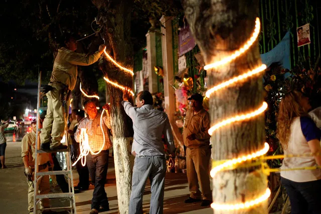 Municipal employees decorate a tree in preparation for an outdoor mass in memory of late iconic Mexican singer Juan Gabriel, outside his house in Ciudad Juarez, Mexico, September 1, 2016. (Photo by Jose Luis Gonzalez/Reuters)