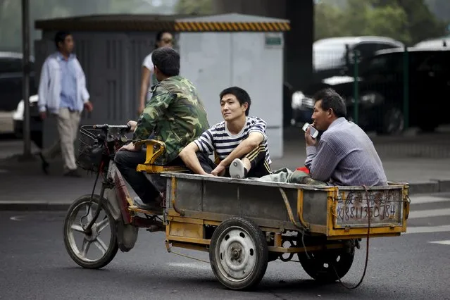 Migrant workers ride on a tricycle past a crossing in Beijing, China, September 22, 2015. (Photo by Jason Lee/Reuters)