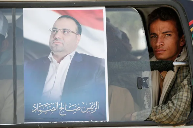 A poster of Saleh al-Sammad, who heads the Supreme Political Council, formed by the Houthi movement and the General People's Congress party to unilaterally rule Yemen by both groups, is seen on the window of a van carrying people to the site of a rally held to show support to the council in the capital Sanaa August 20, 2016. (Photo by Khaled Abdullah/Reuters)